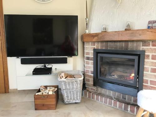 a living room with a fireplace with a flat screen tv at Happiness at Vero in Verviers