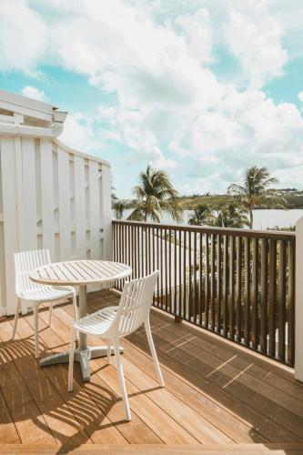 a patio with a table and chairs on a balcony at La Villa Hibiscus, Saint Martin in Cul de Sac