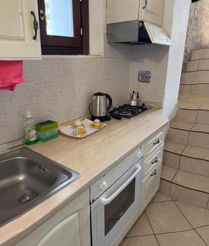 a kitchen counter with a sink and a stove at La Corte dei Celti La fonte in San Benedetto Del Querceto