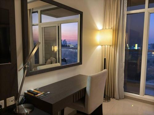 a room with a desk with a mirror and a window at Stylish Studio With Amazing View in Dubai