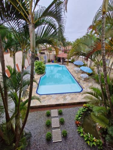 an overhead view of a swimming pool with palm trees at Casa Maravilhosa in Praia Grande
