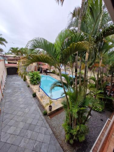 a resort with a swimming pool and palm trees at Casa Maravilhosa in Praia Grande