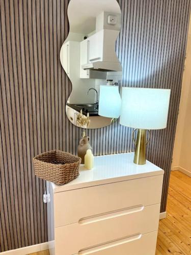 une table avec une lampe au-dessus d'une commode dans l'établissement Studio Centre Ville COTY, au Havre