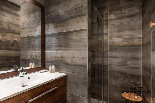 une salle de bain avec un lavabo et une douche dans l'établissement Résidence Ariondaz Fritillaire - Penthouse de charme vue Vallée MAE-9034, à Courchevel
