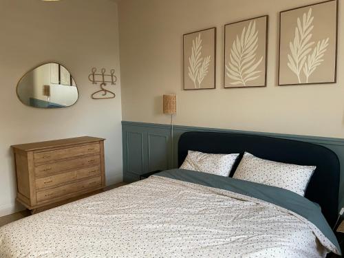 a bedroom with a bed and a mirror and a dresser at La ferme des peupliers in Estaires