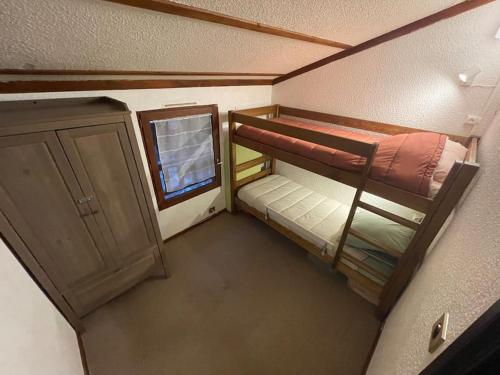 une petite chambre avec deux lits superposés et une fenêtre dans l'établissement Petit chalet cosy prêt des pistes, à Bolquère-Pyrénées 2000
