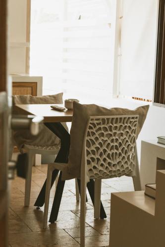 a person sitting at a desk with a table and chairs at La Villa Hibiscus, Saint Martin in Cul de Sac
