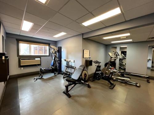 einen Fitnessraum mit mehreren Laufbändern und Heimtrainern in der Unterkunft Cornerstone Lodge by StayIn in Fernie