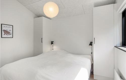 a bedroom with a white bed and a lamp at Awesome Home In Ålbæk With Kitchen in Ålbæk