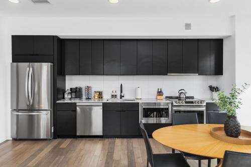a kitchen with stainless steel appliances and a wooden table at Luxury on the River 4 Beds 2.5 Bath, Walk to Downtown in Nashville