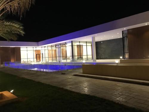 a large building with blue lights on it at night at Jyazelle Resort in Al Ghuţghuţ