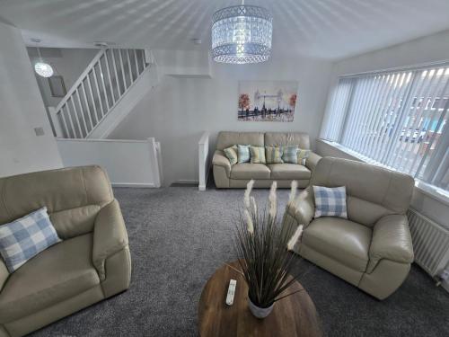 a living room with two couches and a table at New 4bedroom house near Manchester Airport in Handforth