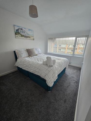 a bedroom with a bed in a room with two windows at New 4bedroom house near Manchester Airport in Handforth