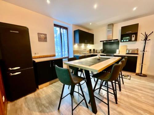a kitchen with a table and chairs in a room at Gîte des Randonneurs, jardin & BBQ et borne VE in Gérardmer