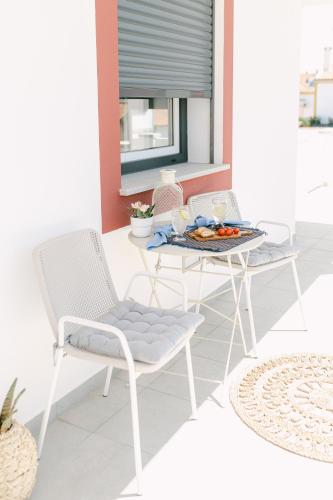 a table and chairs with a tray of food on a patio at Casa dos Rosas in Gavião