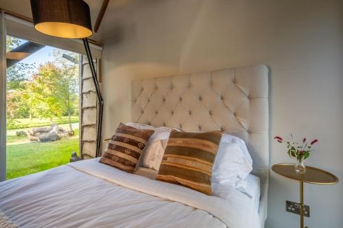 a bedroom with a bed with a large window at Spectacular thousand year old Medieval manor house - Flemings Hall in Ipswich