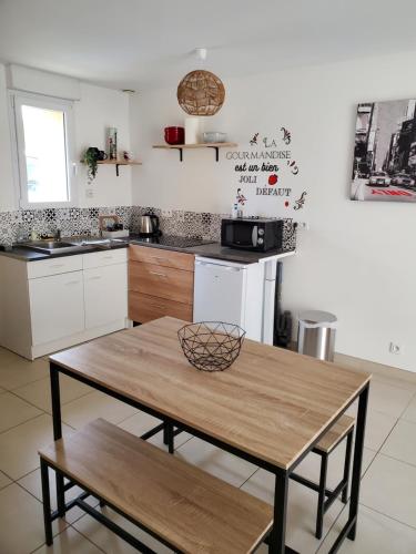 - une cuisine avec une table en bois dans une chambre dans l'établissement Maison 6 voyageurs proche de l'aéroport, à Saint-Aignan-Grand-Lieu