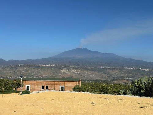 a building in the desert with a mountain in the background at Agriturismo del Nonno in Centuripe