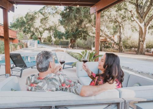 a man and woman sitting at a table with glasses of wine at Serene Vineyard Chateau with Pool, Hot Tub, BBQ in Carmel Valley