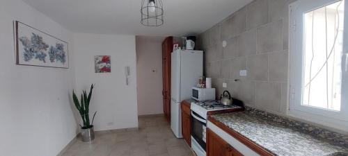 Una cocina con un refrigerador blanco y una estufa. en Kattegat, en Puerto Madryn