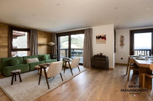 un salon avec un canapé vert et une table dans l'établissement Résidence Les Glaciers - Superbe duplex vue Vallée à Courchevel 1650 MAE-5251, à Courchevel
