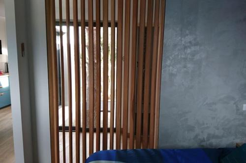 Cette chambre dispose d'une porte coulissante en verre avec des barres en bois. dans l'établissement Maison cosy calme jardin privatif 10mn de la plage, à Frontignan