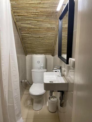 a bathroom with a toilet and a sink and a mirror at Villa à la Résidence Paradis 2 in Sali Poulang