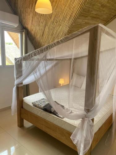 a bunk bed with a canopy in a room at Villa à la Résidence Paradis 2 in Sali Poulang