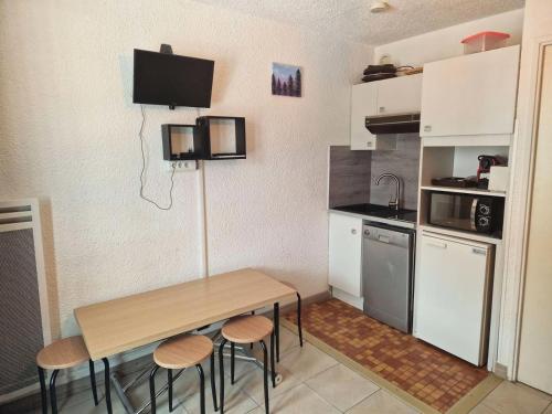 une petite cuisine avec une table et des chaises en bois dans l'établissement Résidence Ski Soleil - Bel appartement 4 couchages Centre station télécabine MAE-0041, à Vars