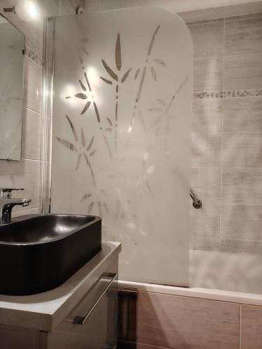 La salle de bains est pourvue d'un lavabo noir et d'une douche. dans l'établissement Résidence Ski Soleil - Bel appartement 4 couchages Centre station télécabine MAE-0041, à Vars