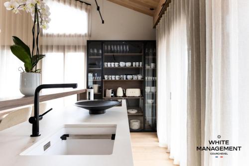 d'une cuisine avec un comptoir, un évier et une fenêtre. dans l'établissement Résidence Les Glaciers - Chaleureux chalet contemporain à Courchevel 1650 MAE-4431, à Courchevel