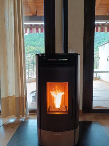 a wood burning stove in a room with a window at EL BALCÓN PANORÁMICO DEL TIÉTAR in Mijares