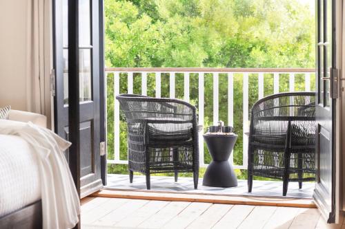 a screened porch with two chairs and a table at One Kensington Boutique Hotel in Cape Town