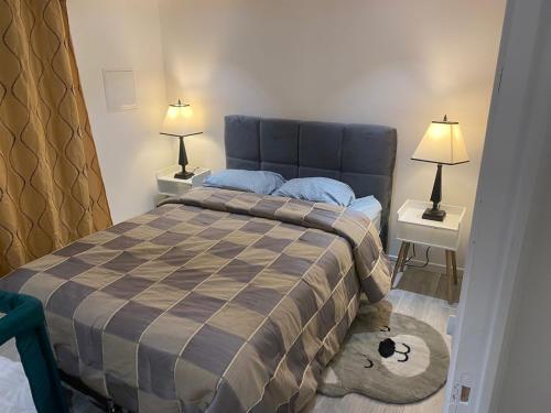 une chambre avec un lit avec deux tables de nuit et deux lampes dans l'établissement Auxilia Home, à Beauchamp