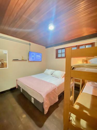 a bedroom with two bunk beds and a tv at Casa Dos Gringobz in Búzios