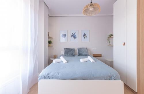 1 dormitorio blanco con 1 cama grande con sábanas azules en Santander Centro I 3 Hab I Wifi I Moderno, en Santander