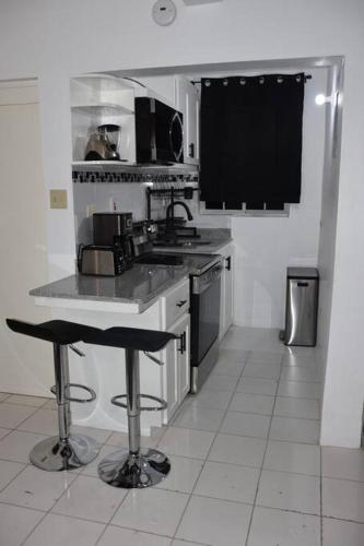 a kitchen with a counter and two bar stools at White River Apartment 9, Great Pond- Ocho Rios in Stanmore Grove