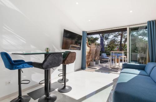 un salon avec un canapé bleu et une table en verre dans l'établissement Village Naturiste R4N - La Villa GreenWood, au Cap d'Agde