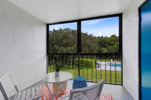 a balcony with a table and chairs and a large window at Oasis 201 - Dune Dream in Titusville