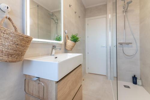 Un baño con lavabo blanco y ducha en Santander Centro I 3 Hab I Wifi I Moderno, en Santander