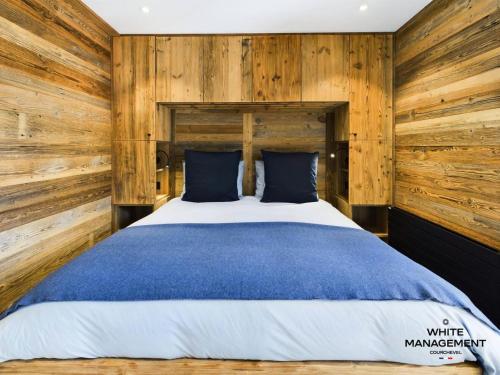 - une chambre avec un grand lit et des murs en bois dans l'établissement Résidence Ariondaz DaphnÉe - Appartement montagnard moderne pour 4 personnes MAE-8971, à Courchevel