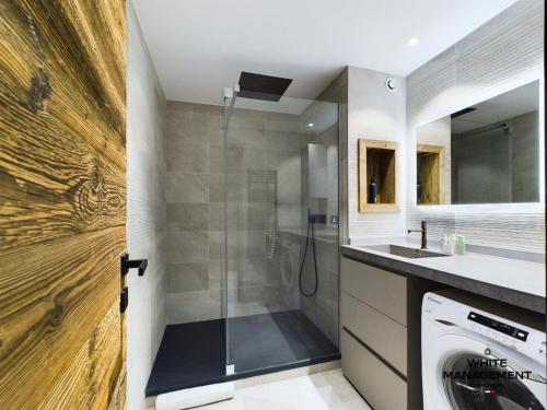 une salle de bain avec douche et machine à laver dans l'établissement Résidence Ariondaz DaphnÉe - Appartement montagnard moderne pour 4 personnes MAE-8971, à Courchevel