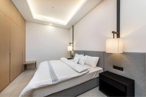 una camera da letto con un letto bianco e una televisione di Anantara Palm Jumeirah Studio Sea View a Dubai