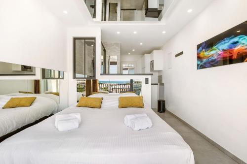 - une chambre avec 3 lits et un tableau mural dans l'établissement Village Naturiste R4N - Le Libertino Heliopolis, au Cap d'Agde