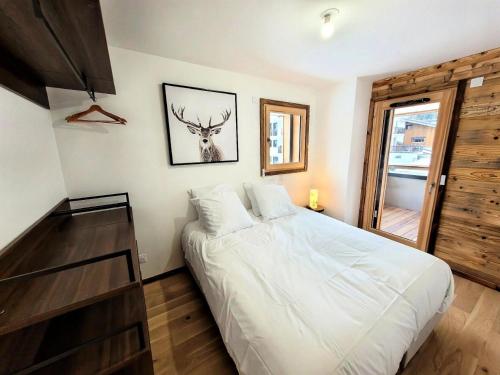 - une chambre dotée d'un lit avec une photo de cerf sur le mur dans l'établissement Résidence Essentiel - Appartement neuf, 6 personnes au centre MAE-1061, aux Gets