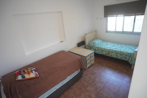 a small bedroom with two beds and a window at Moderno departamento caseros in Caseros