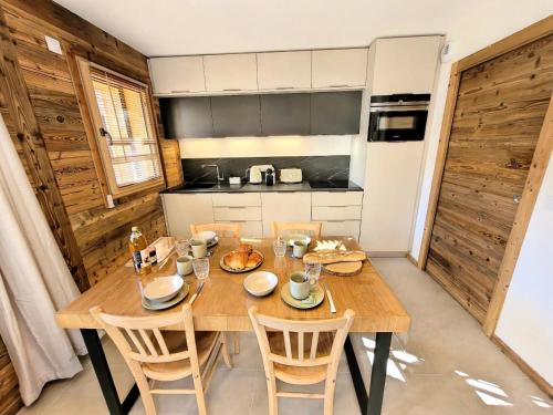 une salle à manger avec une table et des chaises en bois dans l'établissement Résidence Essentiel - Appartement de charme au centre du village MAE-1731, aux Gets