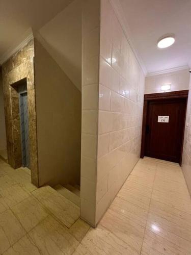 an empty hallway with a door and a tile floor at مسكن التل in Al Madinah