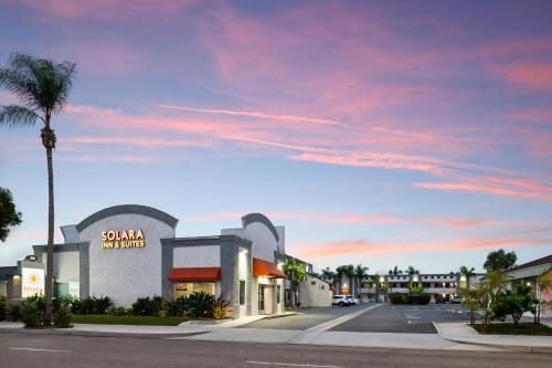 a street with a palm tree and a building at Solara Inn and Suites in Anaheim