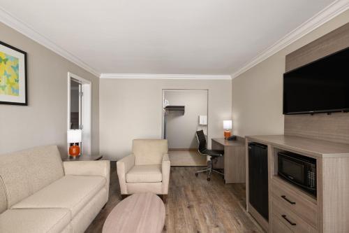a living room with a couch and a flat screen tv at Solara Inn and Suites in Anaheim
